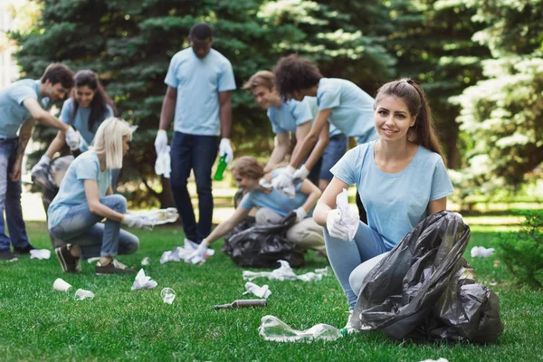 Csoport az önkéntesek, a szemetet táskák tisztító park — Stock Fotó