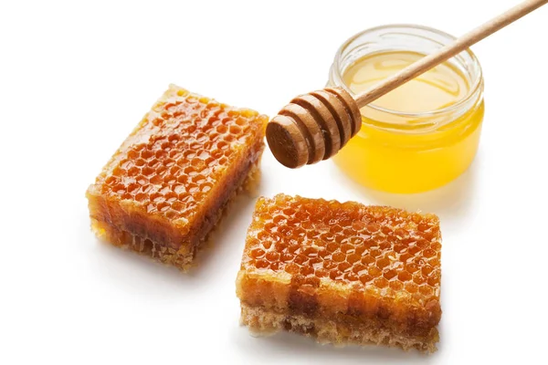 Pot vol verse honing en honingraten geïsoleerd op wit — Stockfoto
