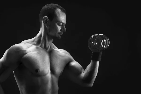 Strong athletic man with dumbbell showes naked muscular body — Stock Photo, Image
