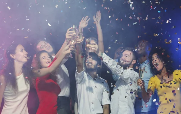 Glada vänner spottar glas champagne på fest — Stockfoto