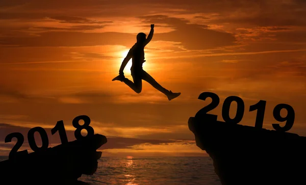 Mannen hoppar mellan 2018 och 2019 år vid solnedgången — Stockfoto