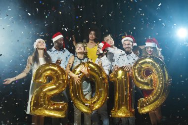 Altın renkli numara balonlar tutan gençlerin Grup