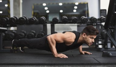 Güç ve motivasyon. Spor salonunda push-up yapıyor adam