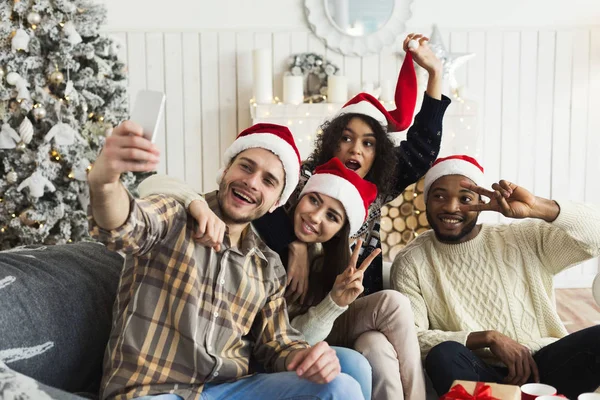 Groupe de jeunes amis dans Santas chapeaux prendre un selfie — Photo