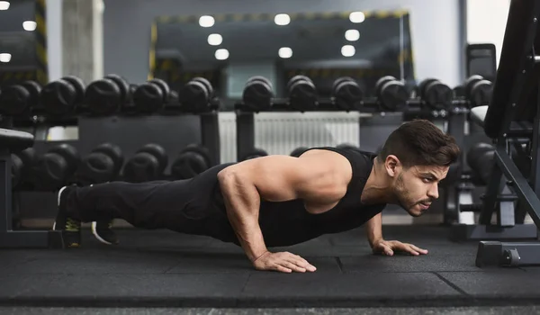 Força e motivação. Homem de sportswear fazendo push-up no ginásio — Fotografia de Stock