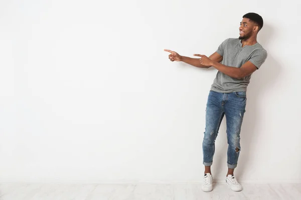 Homem negro excitado apontando dois dedos de lado no espaço de cópia — Fotografia de Stock