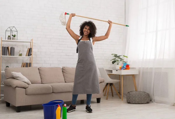Strong beautiful woman holding mop above head — Stock Photo, Image