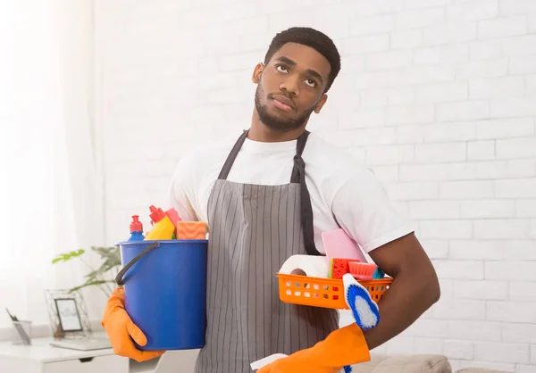 Black man boring of cleaning work at home