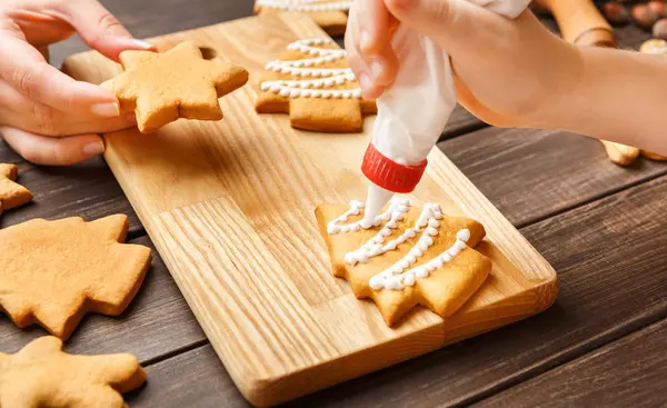 Kind und Mutter dekorieren weihnachtliche Lebkuchen — Stockfoto