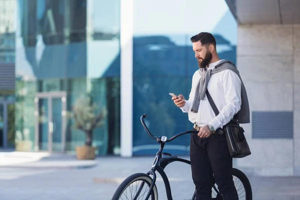 Empresário usando telefone celular enquanto vai ao escritório . — Fotografia de Stock