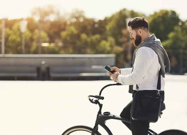 彼は自転車にもたれて、携帯電話を保持している実業家 — ストック写真