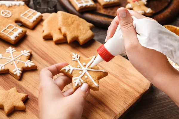 Decoratie kerst bakkerij. Vrouw beglazing zelfgemaakte koekjes — Stockfoto