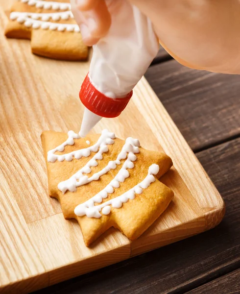 Lebkuchen mit weißem Zuckerguss verzieren, Nahaufnahme — Stockfoto