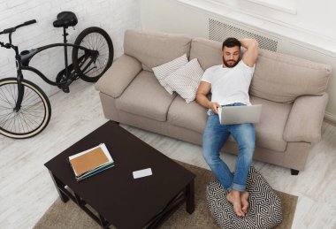 yakışıklı bir adam üstünde laptop evde çalışma