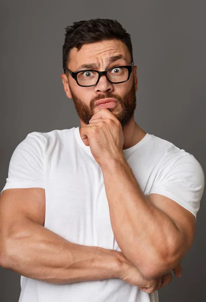 Muskulöser Mann mit Brille und Hand am Kinn — Stockfoto