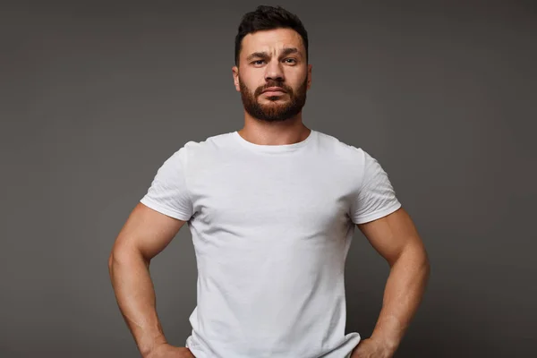 Hombre serio en blanco camiseta en blanco, fondo del estudio —  Fotos de Stock