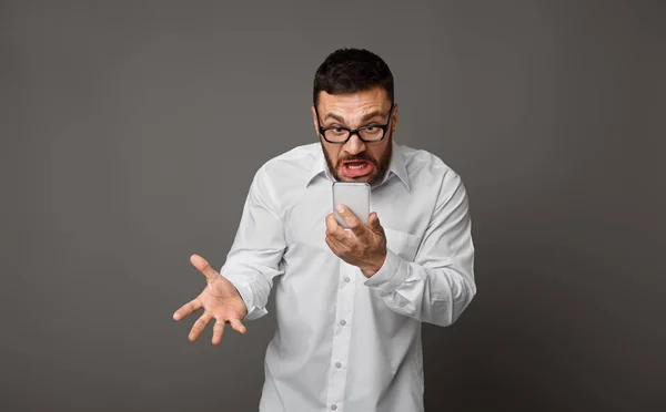Enojado hombre de negocios furioso en gafas con teléfono celular —  Fotos de Stock