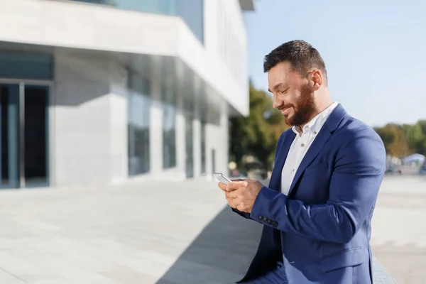 Biznesmen przy użyciu telefonu komórkowego aplikacji poza w biurze — Zdjęcie stockowe