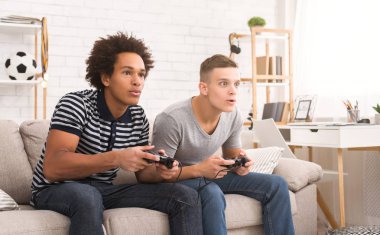 Çeşitli genç çocukların oyun konsolu evde oynarken