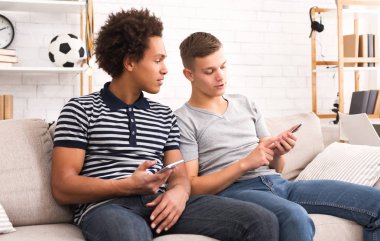 İki arkadaş medya içeriği smartphone içinde izlerken