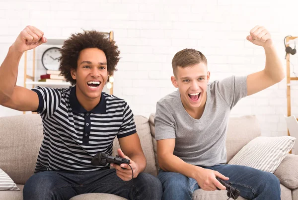 Dois jogadores jogando videogames online e celebrando o sucesso da equipe — Fotografia de Stock