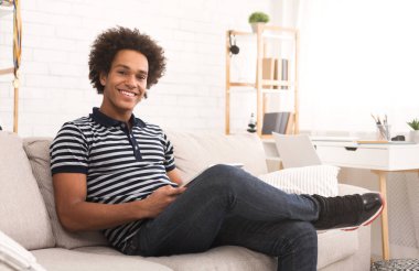 Evde vakit. Genç adam evde tablet kullanma