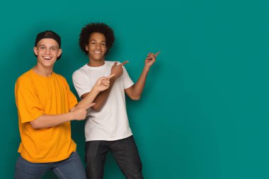 İki mutlu arkadaş üzerinde kopya alanı, uzak parmakları işaret arka plan mavi