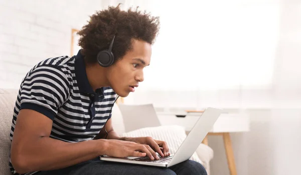 Adolescente afroamericano concentrado jugando videojuegos en el portátil — Foto de Stock