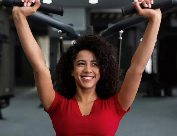 Donna afro-americana che si esercita in palestra sulla macchina — Foto Stock