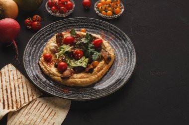 Humus sebze ve siyah arka plan üzerine deniz ürünleri ile