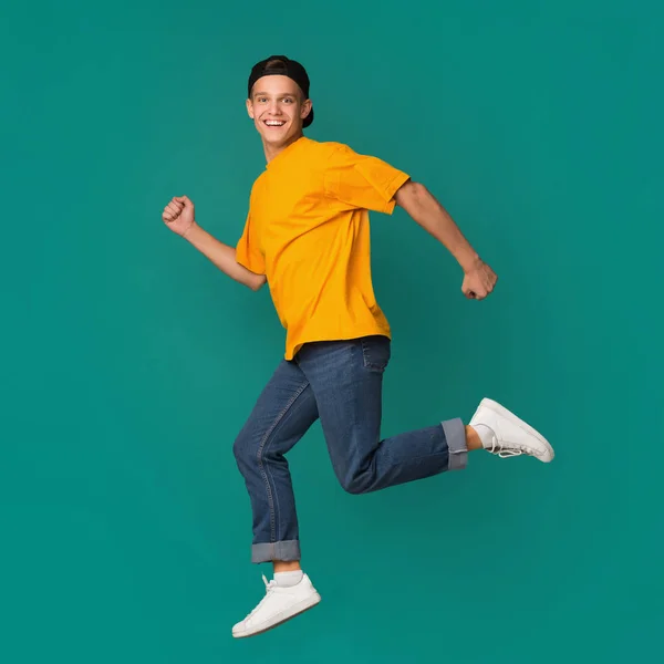 Heyecanlı genç çocuk mavi stüdyo arka plan atlama — Stok fotoğraf
