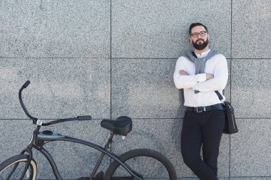 Duvar onun bisiklet ile inşa karşı ayakta işadamı.