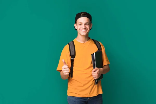 Raccomandare. Teenager mostrando pollice in su e tenendo libri — Foto Stock