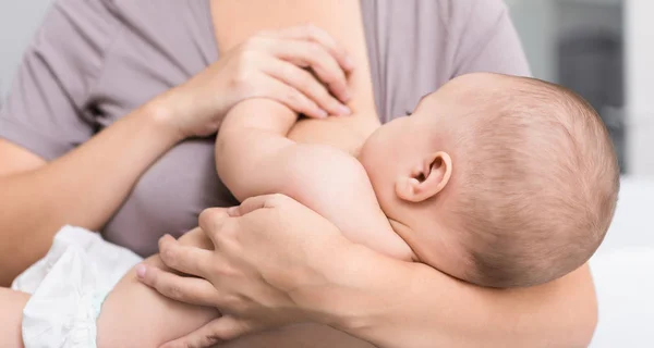 Young mom breast feeding her newborn child — Stock Photo, Image