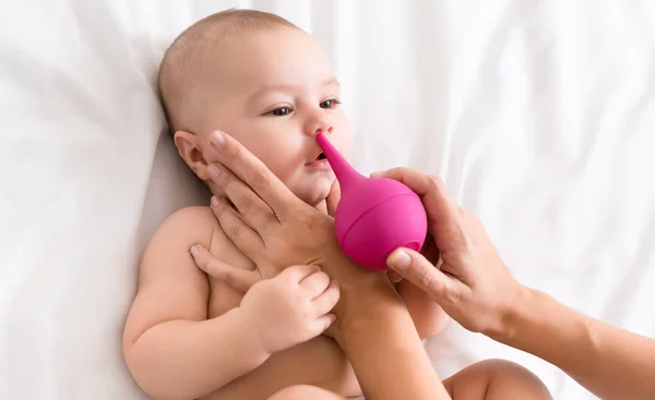 Bebé recién nacido recibiendo limpieza de la nariz con limpiador —  Fotos de Stock