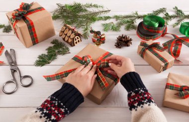 Eller, dağınık masa artalanını Xmas hediye paketleme