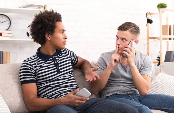 Adolescente mostrando señal de silencio mientras habla por teléfono — Foto de Stock