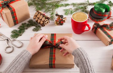 Eller, dağınık masa artalanını Xmas hediye paketleme