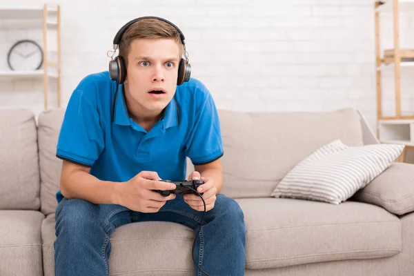 Teen guy spielend videospiele mit joystick — Stockfoto