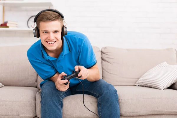 Молодой парень наслаждается веб-игрой, играя с джойстиком — стоковое фото