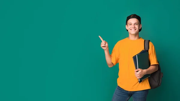 Tiener student met boeken wijst op kopie ruimte — Stockfoto