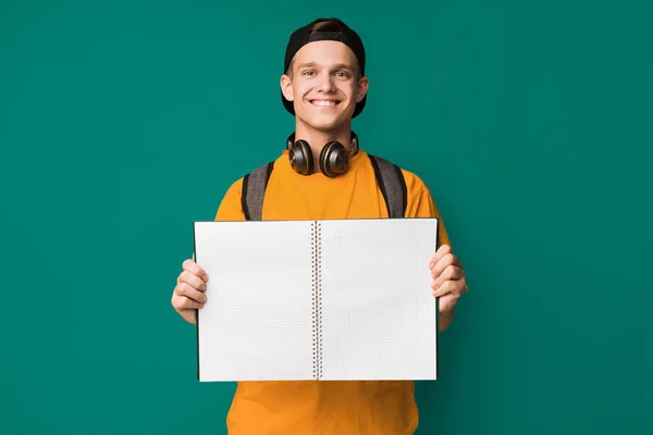 Tiener jongen houdt van lege laptop over achtergrond — Stockfoto