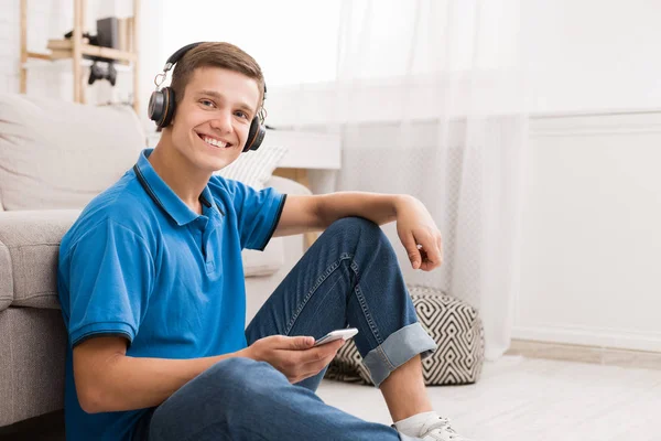 Chico feliz usando el teléfono inteligente en casa, espacio de copia — Foto de Stock