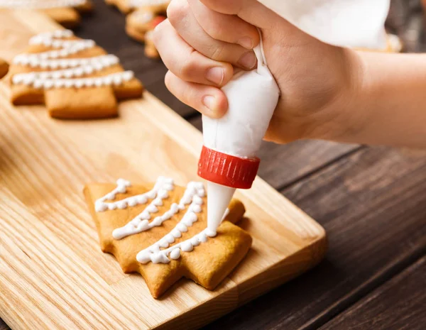 Kid fazendo decoração em biscoito de gengibre, close-up — Fotografia de Stock