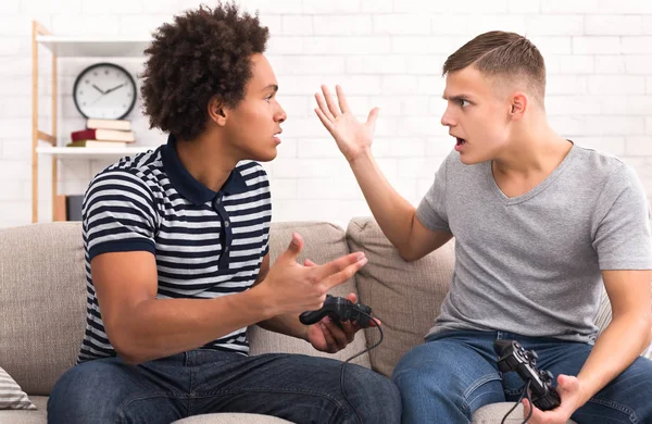 Мальчики-подростки ссорятся во время игры на консоли — стоковое фото