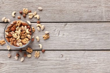 Ahşap masa üzerinde karışık kuruyemiş ile kase