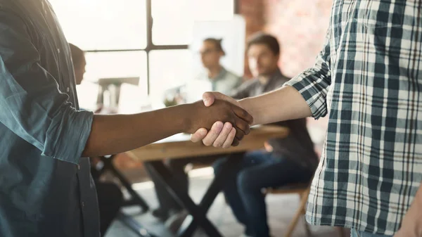 Handshake mezi africké a kavkazské muži na zasedání — Stock fotografie