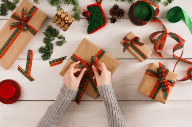 Eller, dağınık masa artalanını Xmas hediye paketleme
