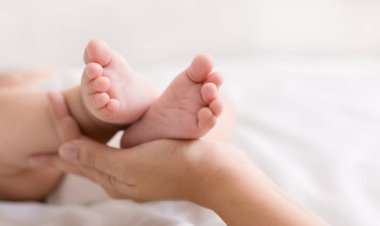 Anne eller tatlı küçük bebek ayaklar