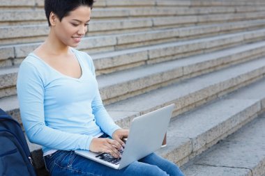 Bir dizüstü bilgisayar açık havada üzerinde çalışan kadın serbest meslek gülümseyen